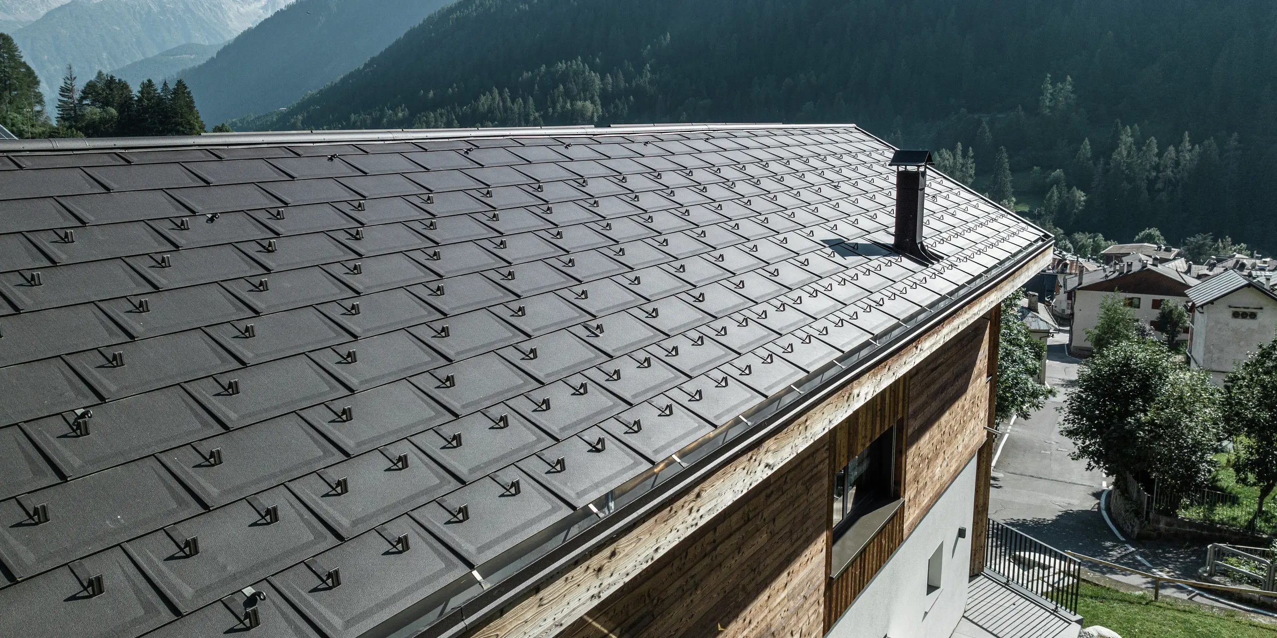 Gros plan sur les R.16 PREFA en P.10 brun qui confèrent à ce refuge de montagne à Cogolo, Val di Sol, un aspect élégant et offrent également une protection maximale contre les conditions météorologiques extrêmes. La toiture en aluminium durable avec pare-neige intégrés assure sécurité et stabilité aux hauteurs alpines. Une toiture esthétique et facile d'entretien pour des générations.