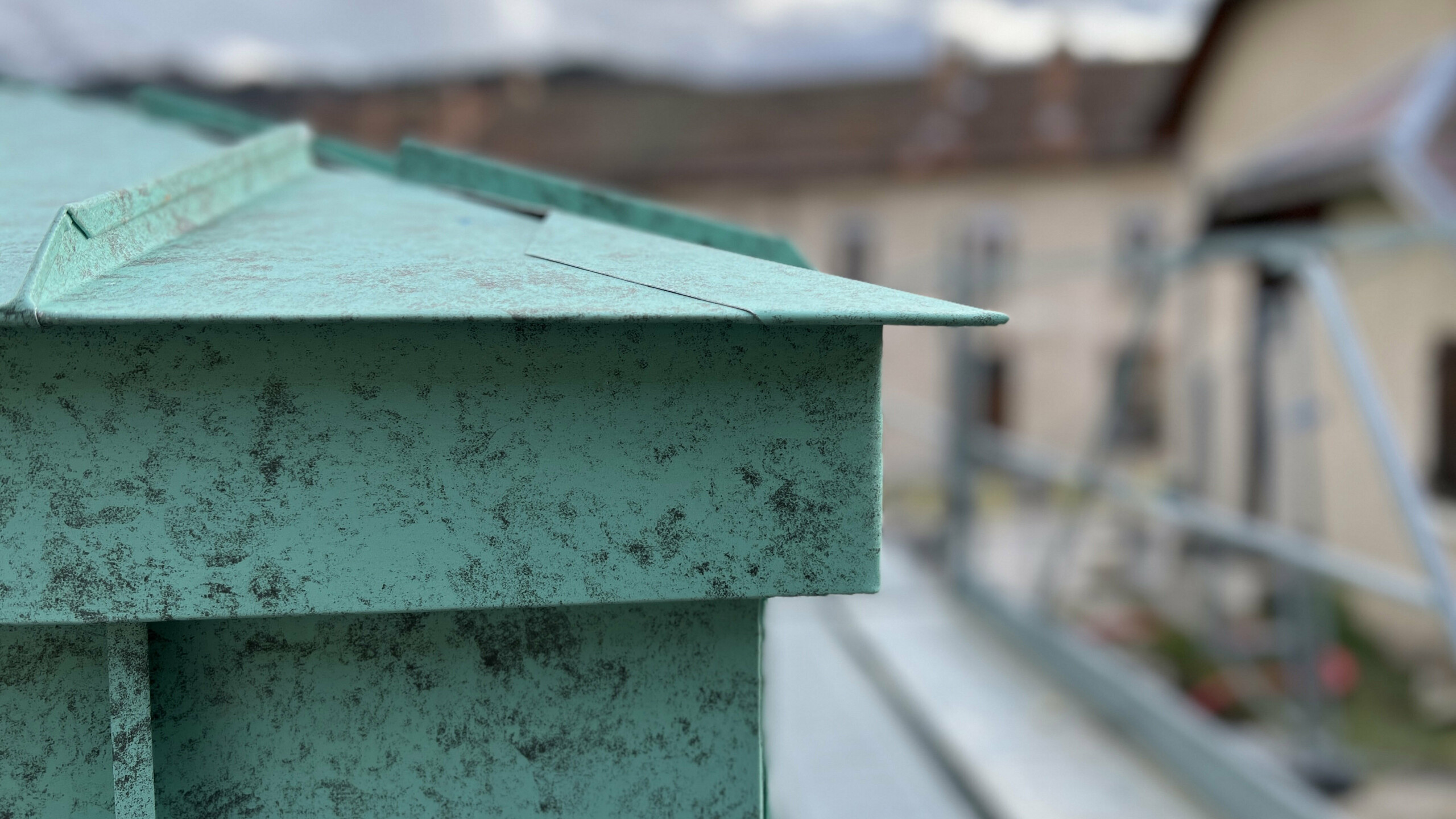 Zoom sur le détail de raccord entre la toiture et la façade, tous deux réalisés en joint debout en aluminium PREFA