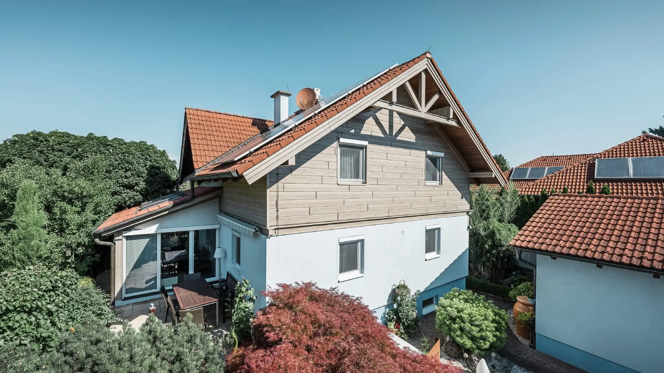 Façade d’une maison individuelle dont l’étage a été habillé avec des Sidings aspect bois de couleur chêne gris