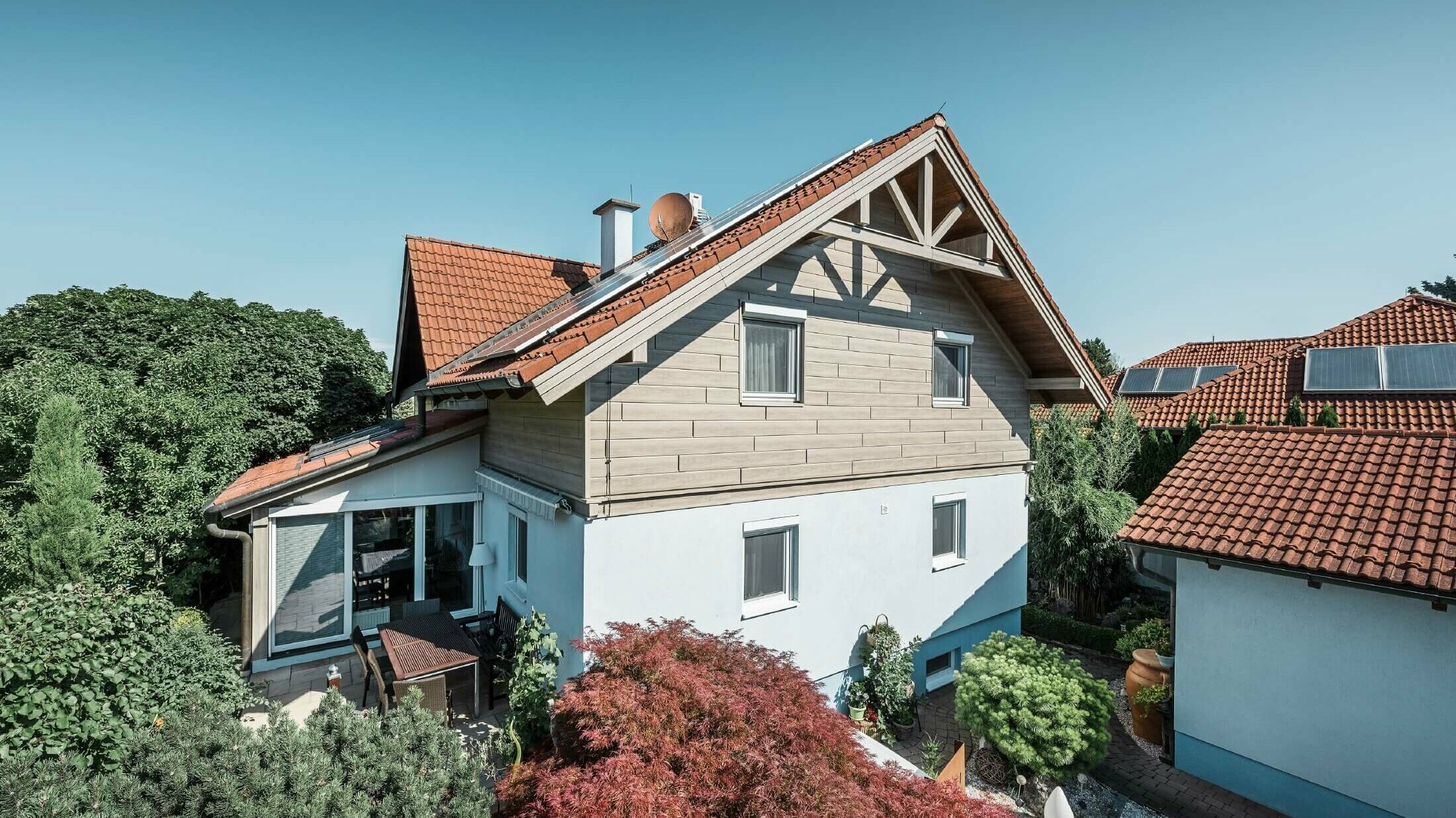 Façade d’une maison individuelle dont l’étage a été habillé avec des Sidings aspect bois de couleur chêne gris