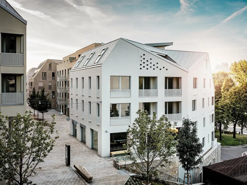 Le quartier résidentiel moderne de Vydrica à Bratislava se distingue par un style architectural affirmé et un paysage urbain paisible. Les toits à pignons à forte pente, agrémentés de remarquables puits de lumière, sont recouverts de tuiles en aluminium PREFA, coloris P.10 Blanc Prefa, Bronze et P.10 Brun Sable, créant ainsi un point focal élégant baigné de soleil. La précision des lignes et l'homogénéité des surfaces soulignent la grande qualité de la conception. L'aluminium PREFA est reconnu pour sa durabilité, sa légèreté et son excellente résistance aux intempéries – des atouts idéaux pour les toitures aux formes complexes et pour une enveloppe de bâtiment durable et nécessitant peu d'entretien.