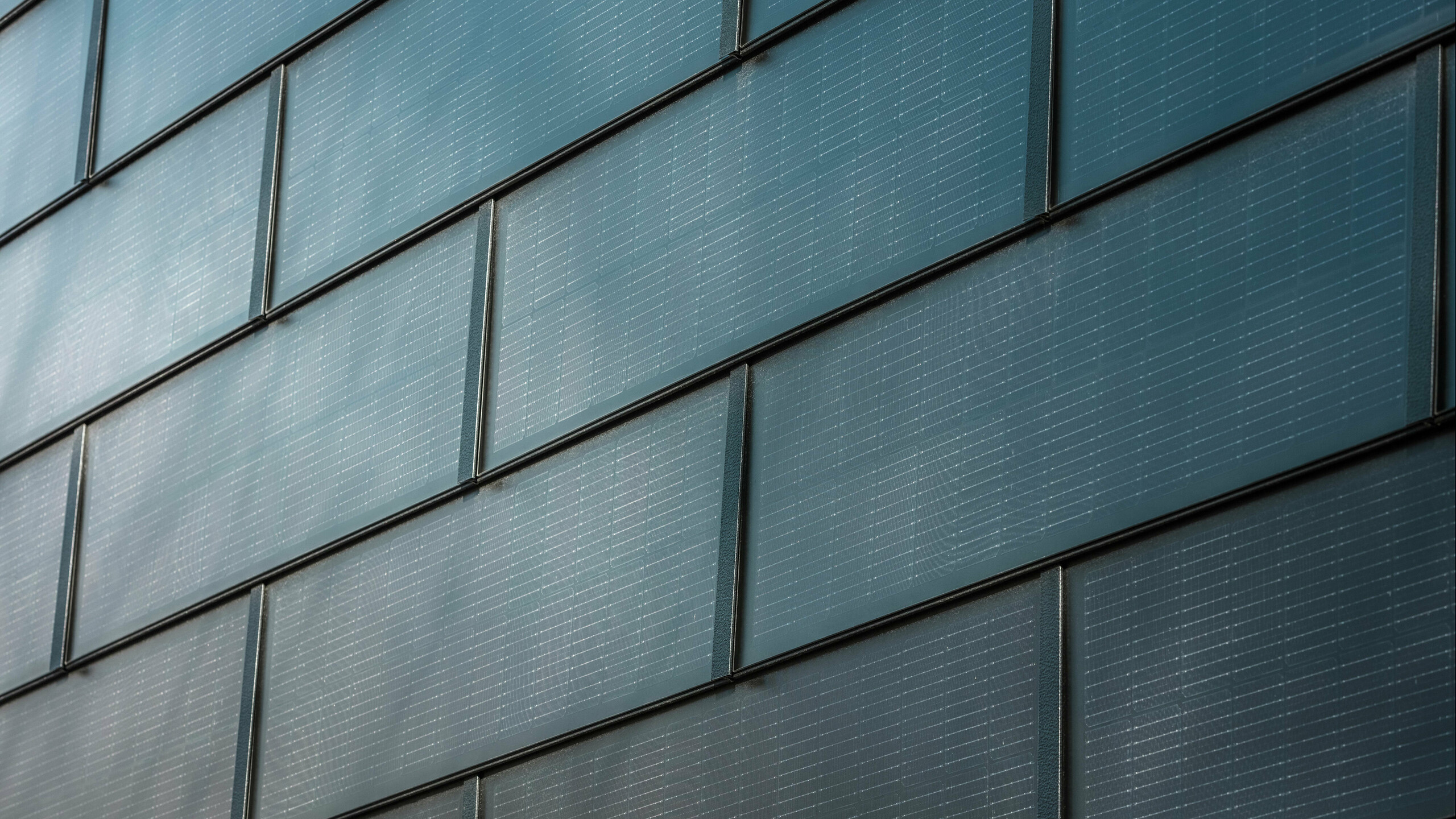 Gros plan sur les tuiles solaires PREFA montées sur une façade.