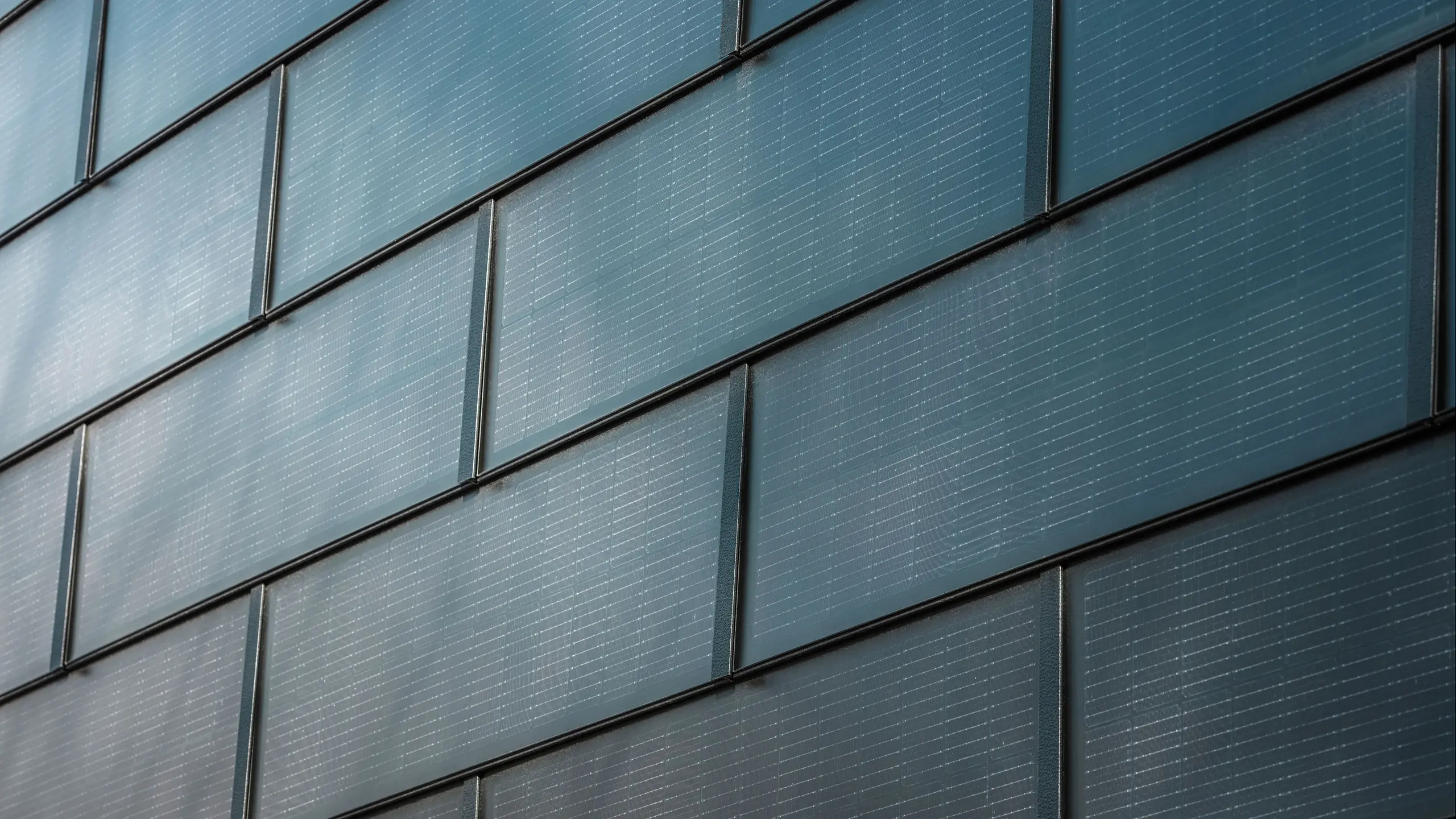 Gros plan sur les tuiles solaires PREFA montées sur une façade.