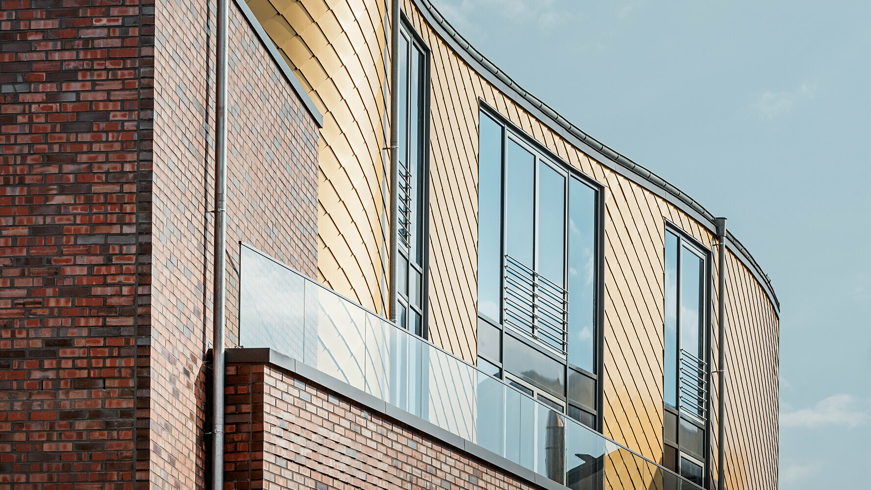 Revêtement de façade avec losanges PREFA dorés associé à une façade en briques