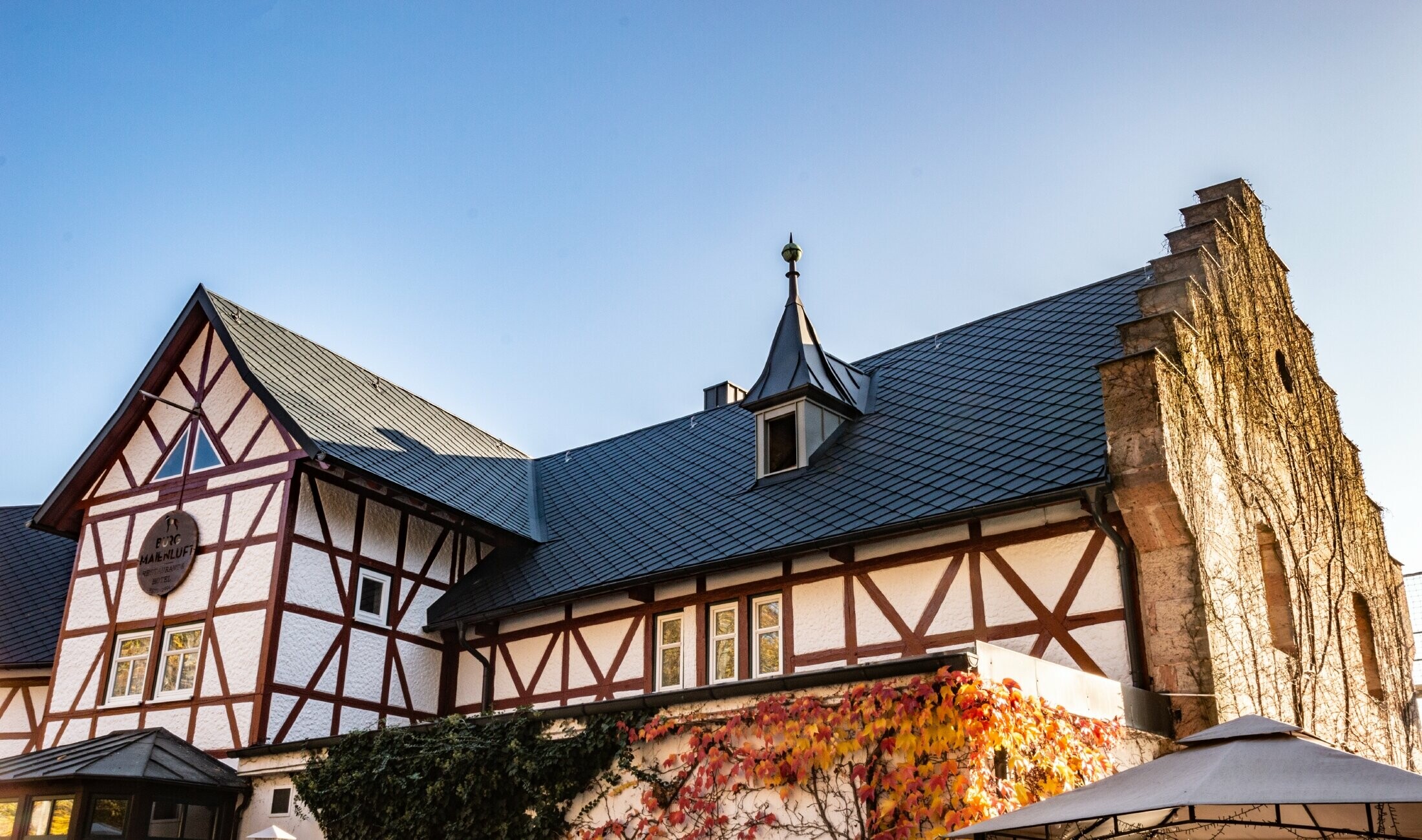 L’hôtel Burg Maienluft a été recouvert de losanges de toiture 29 × 29 PREFA couleur anthracite, la façade est à colombage.