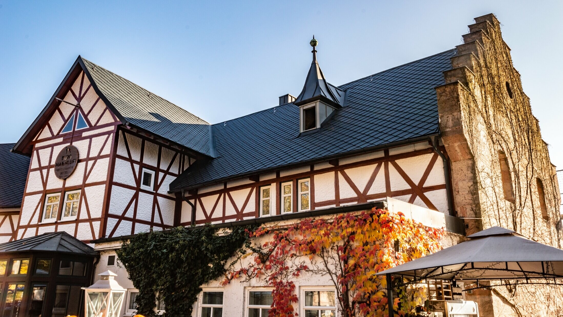 L’hôtel Burg Maienluft a été recouvert de losanges de toiture 29 × 29 PREFA couleur anthracite, la façade est à colombage.