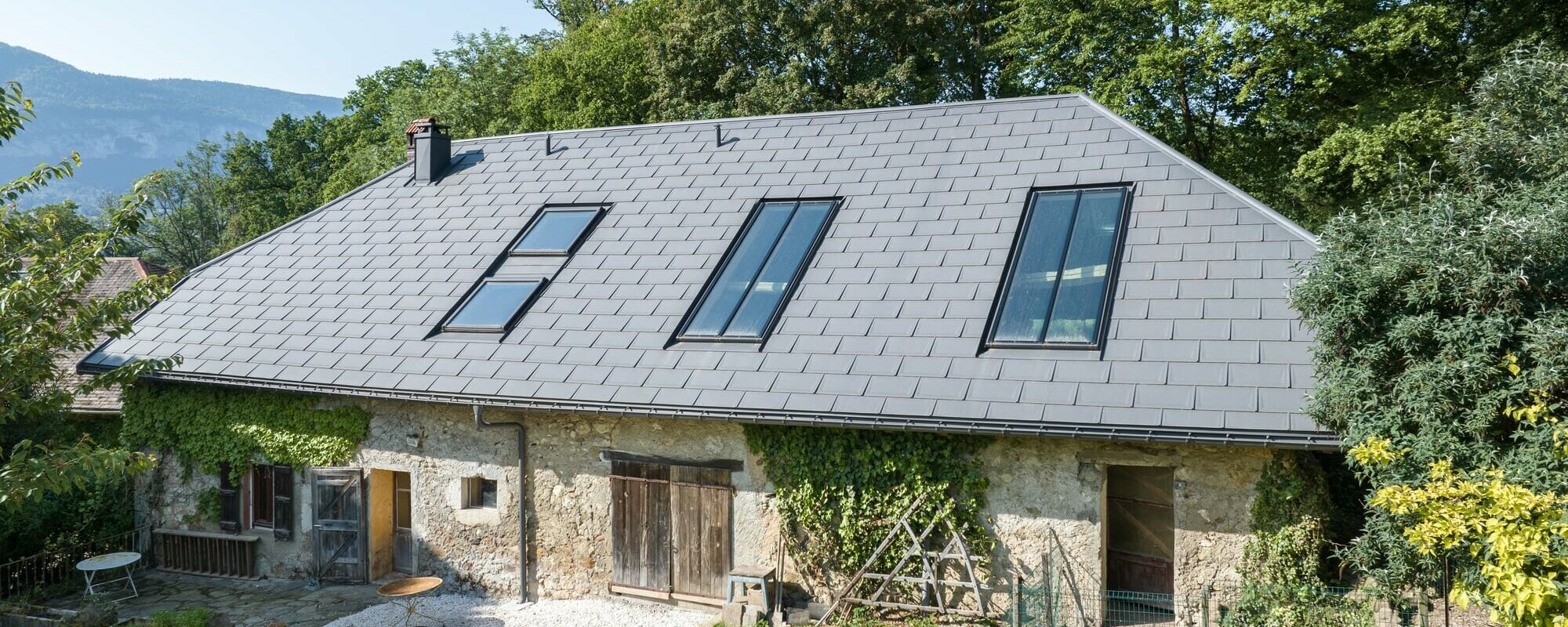 Vue latéral d'une ferme de Haute-Savoie avec un toit gris
