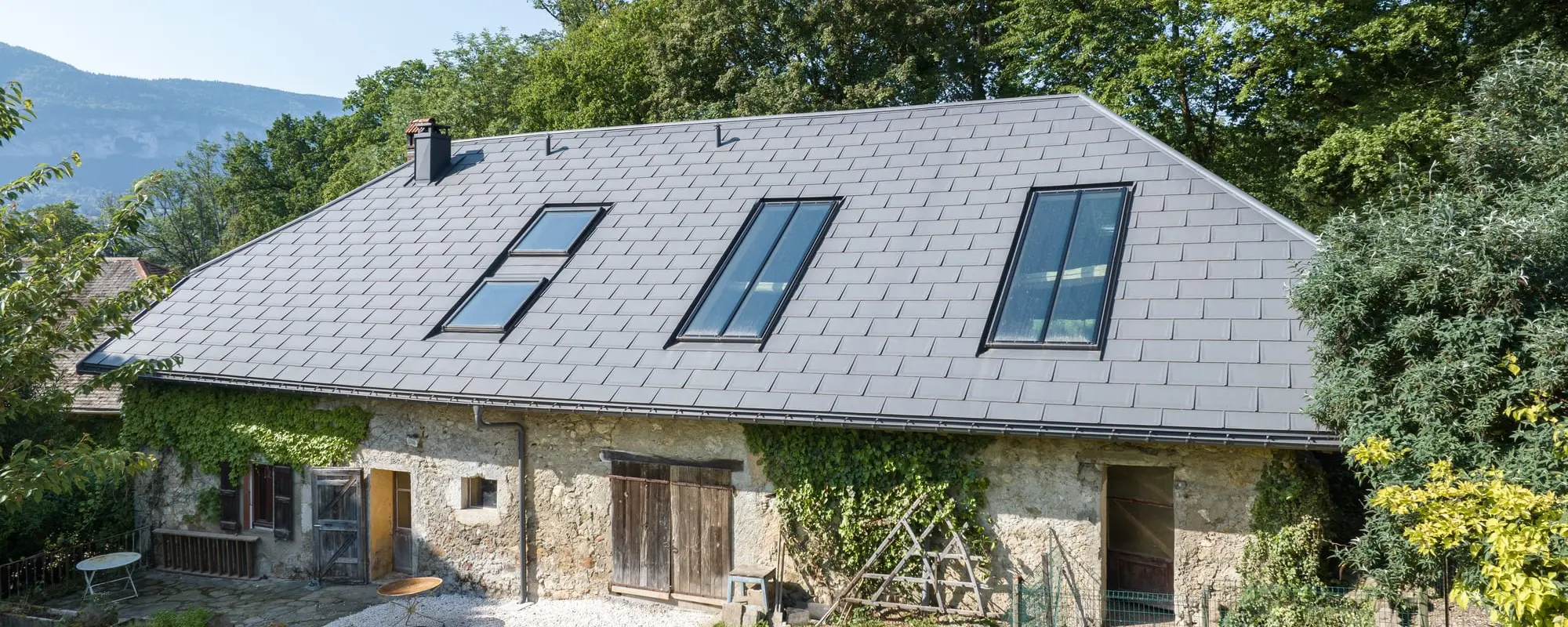 Vue latéral d'une ferme de Haute-Savoie avec un toit gris