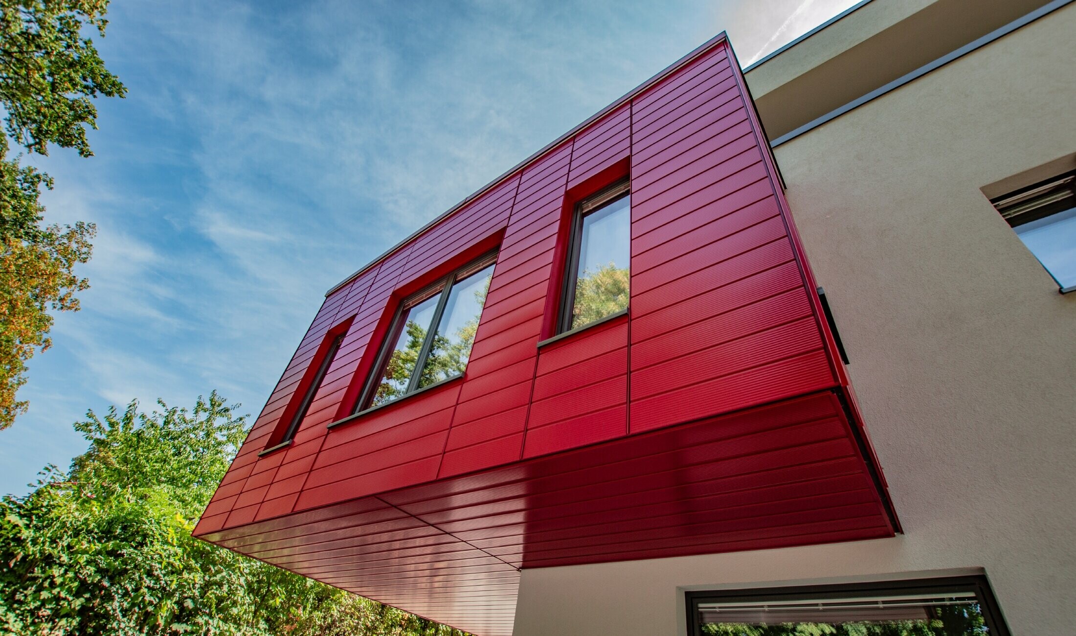 Oriel recouvert de Sidings PREFA en finition lignée rouge rubis, les Sidings sont posés à l’horizontale.