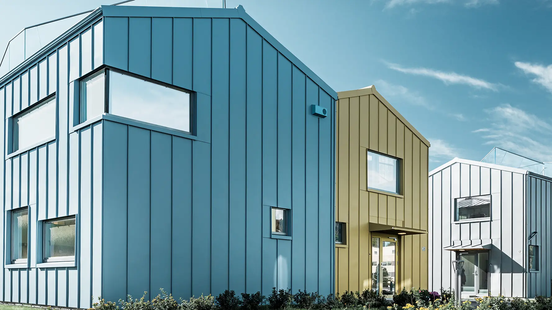 Des maisons individuelles au sein d'un lotissement aux toitures et façades colorés en aluminium