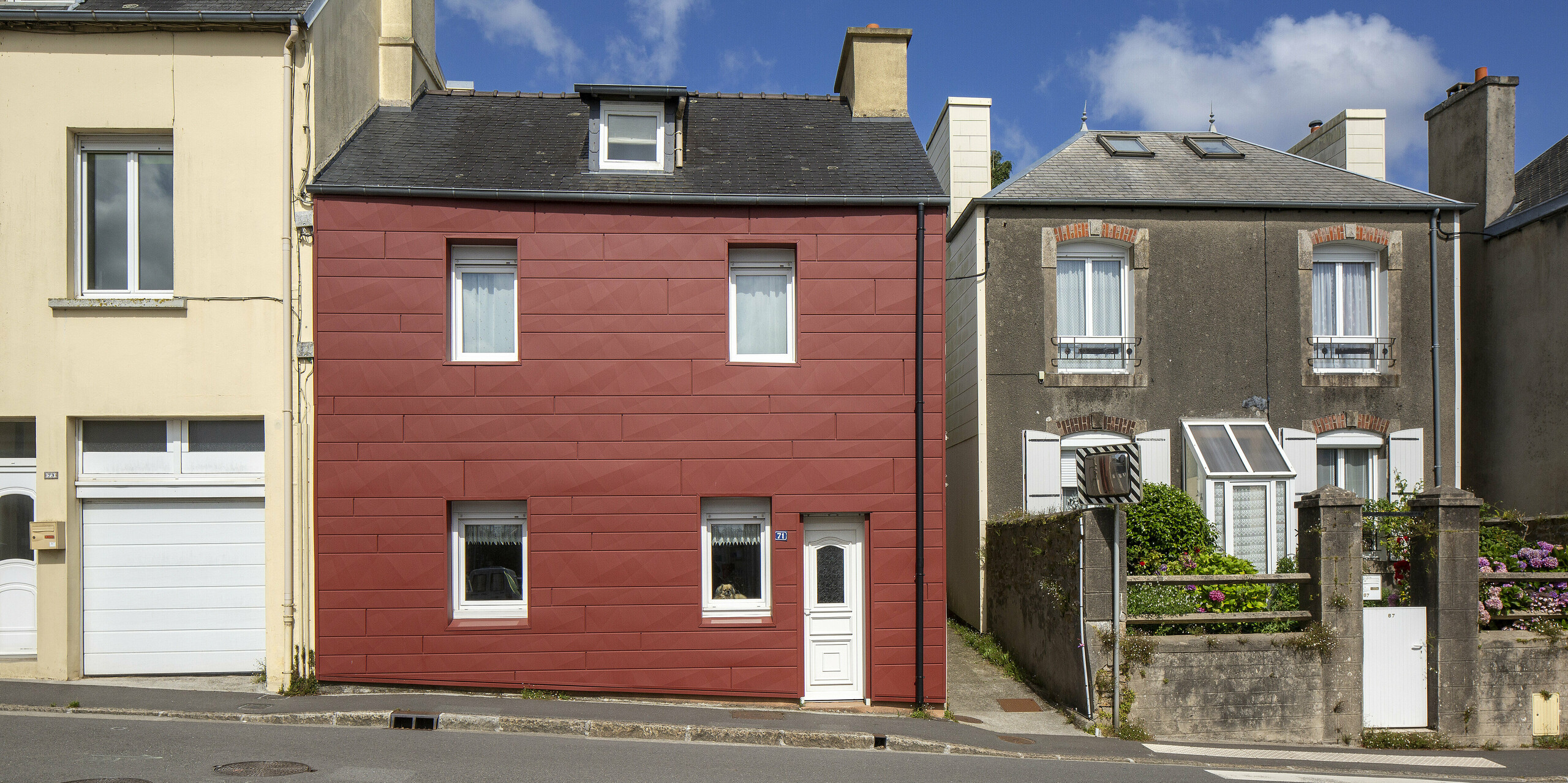 Un exemple parfait de rénovation de façade réussie : cette maison individuelle à Brest séduit par ses panneaux de façade modernes Siding.X en rouge oxyde P.10. La géométrie audacieuse et la couleur vibrante la distinguent nettement de son environnement. Un élément architectural remarquable, durable et sans entretien, qui apporte une nouvelle dimension au paysage urbain.