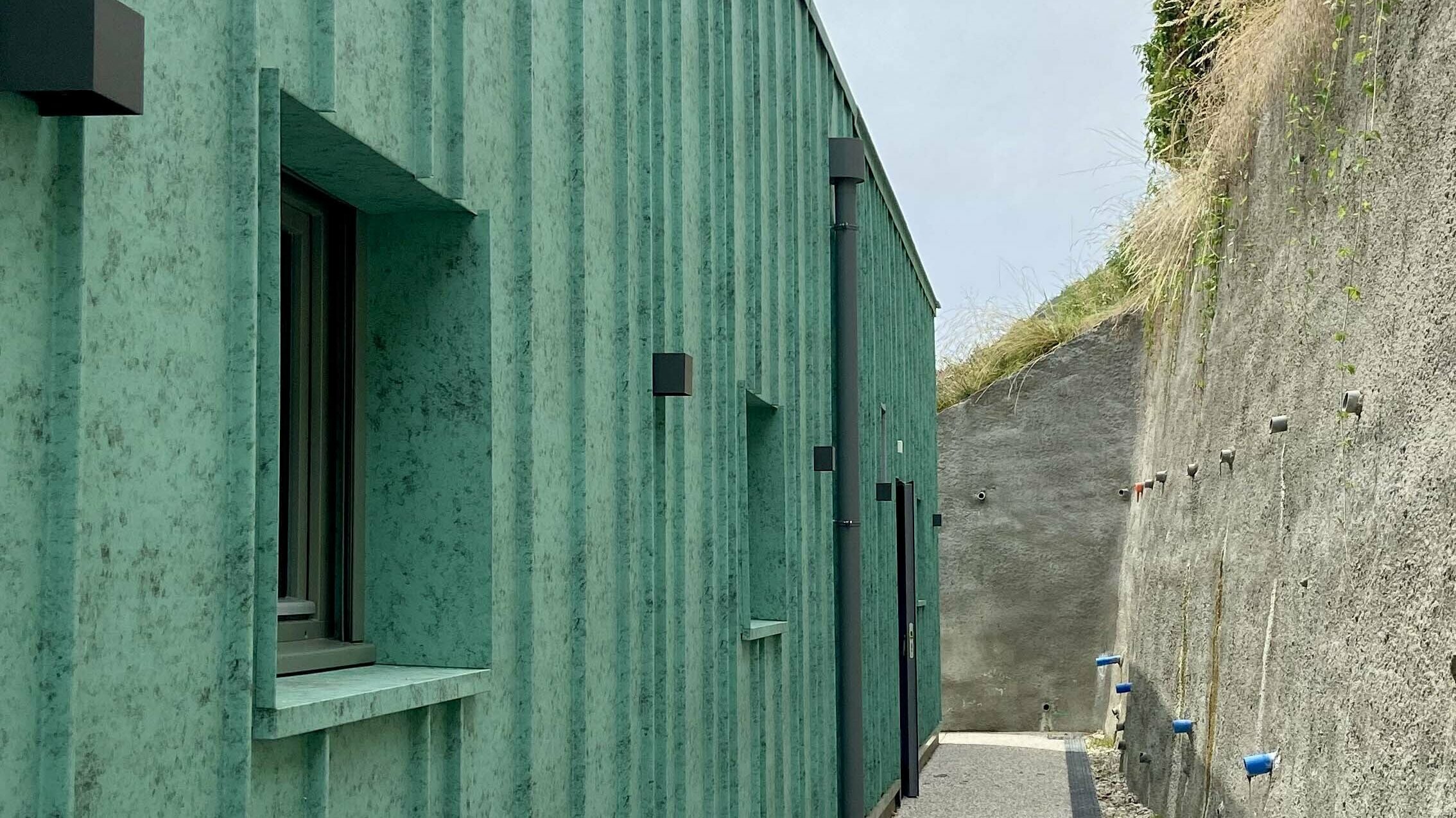 Vue de près de la façade de la nouvelle crèche des Adrets dont le bardage a été réalisé en joint debout en aluminium en pose aléatoire.