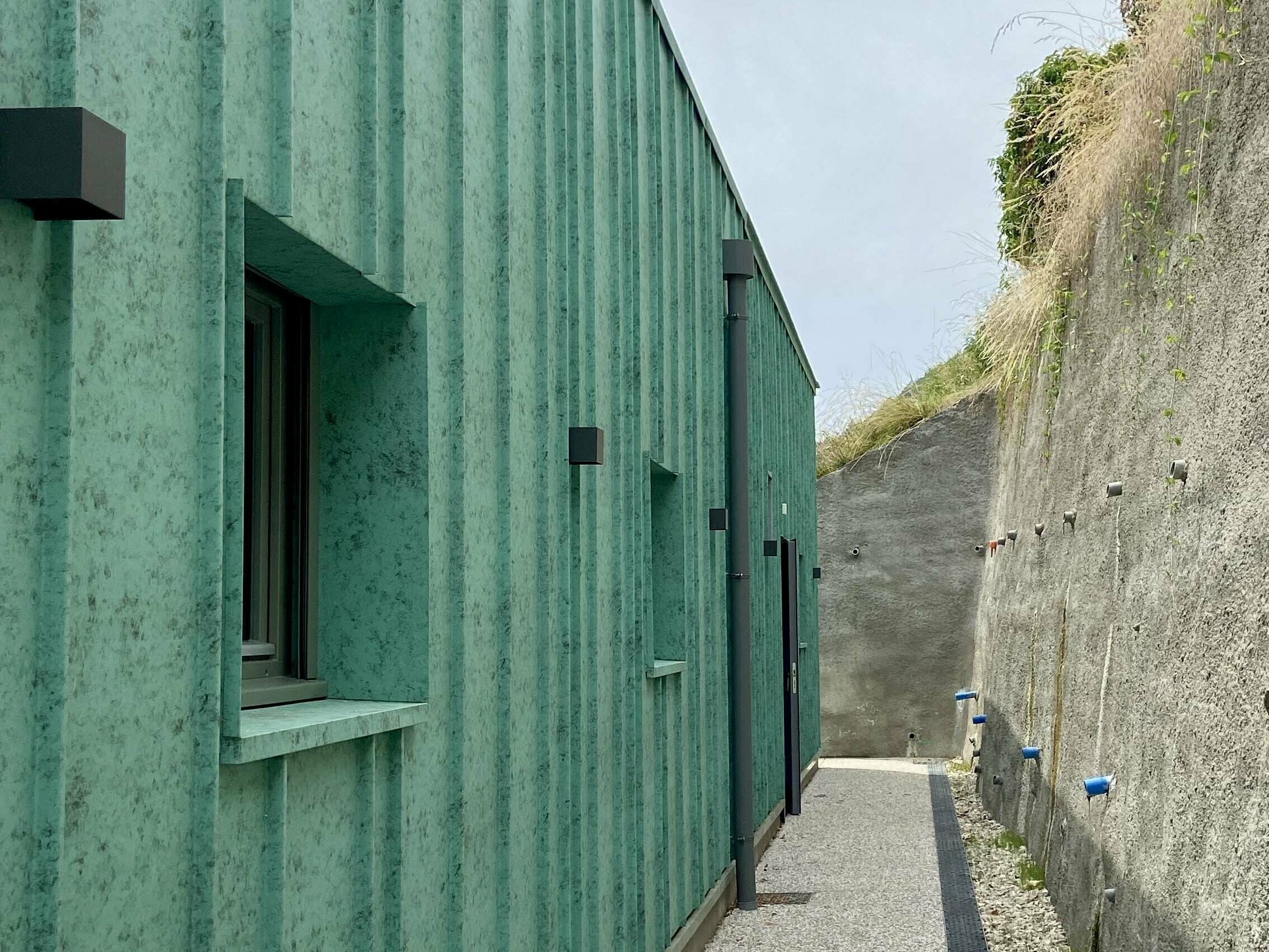 Vue de près de la façade de la nouvelle crèche des Adrets dont le bardage a été réalisé en joint debout en aluminium en pose aléatoire.