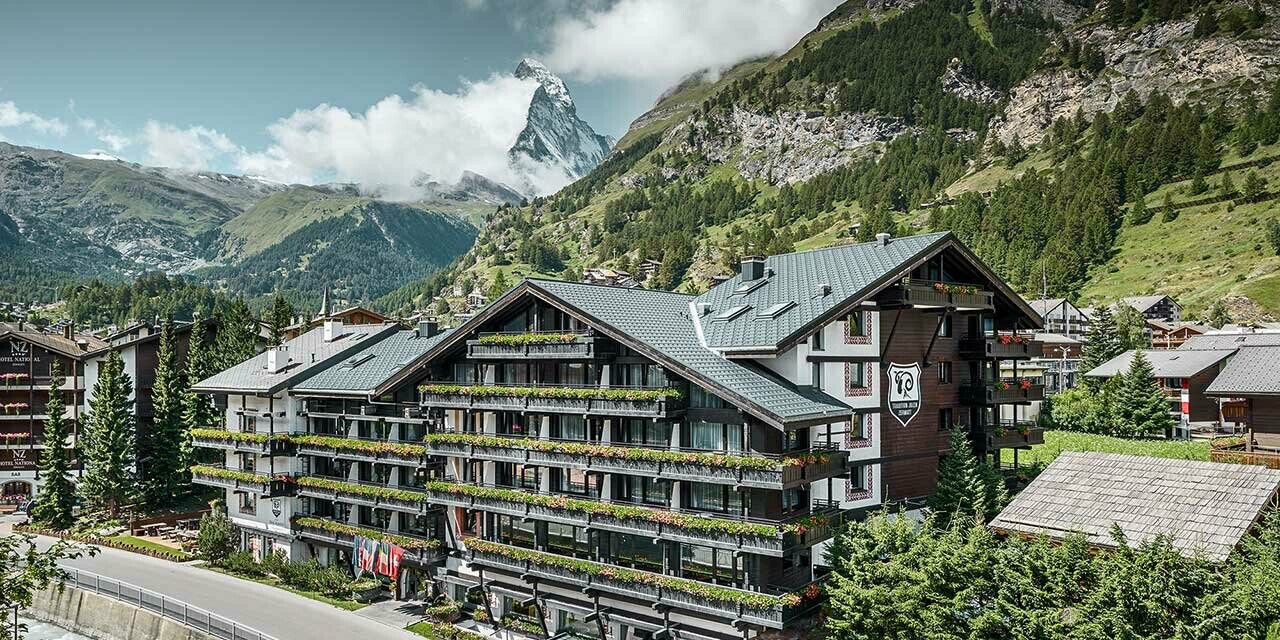 Hôtel Alpenhof à Zermatt avec balcons, façade en bois foncé et le Cervin en toile de fond — Toiture en aluminium PREFA de couleur anthracite