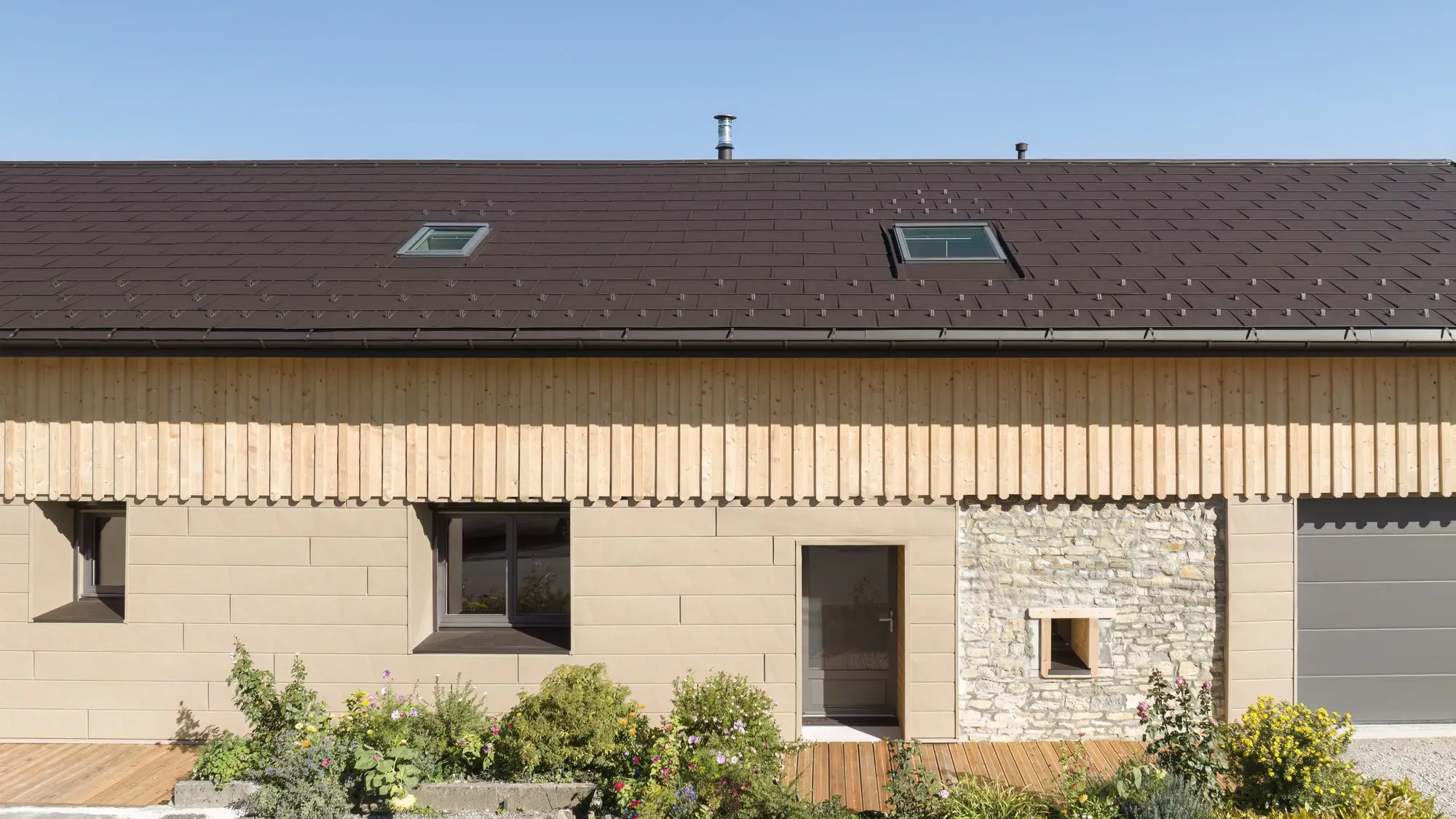 Photo d'ensemble de cette maison individuelle récemment rénovée à l'aide de plusieurs produit PREFA : le R.16 pour la couverture et le Siding.X pour la façade