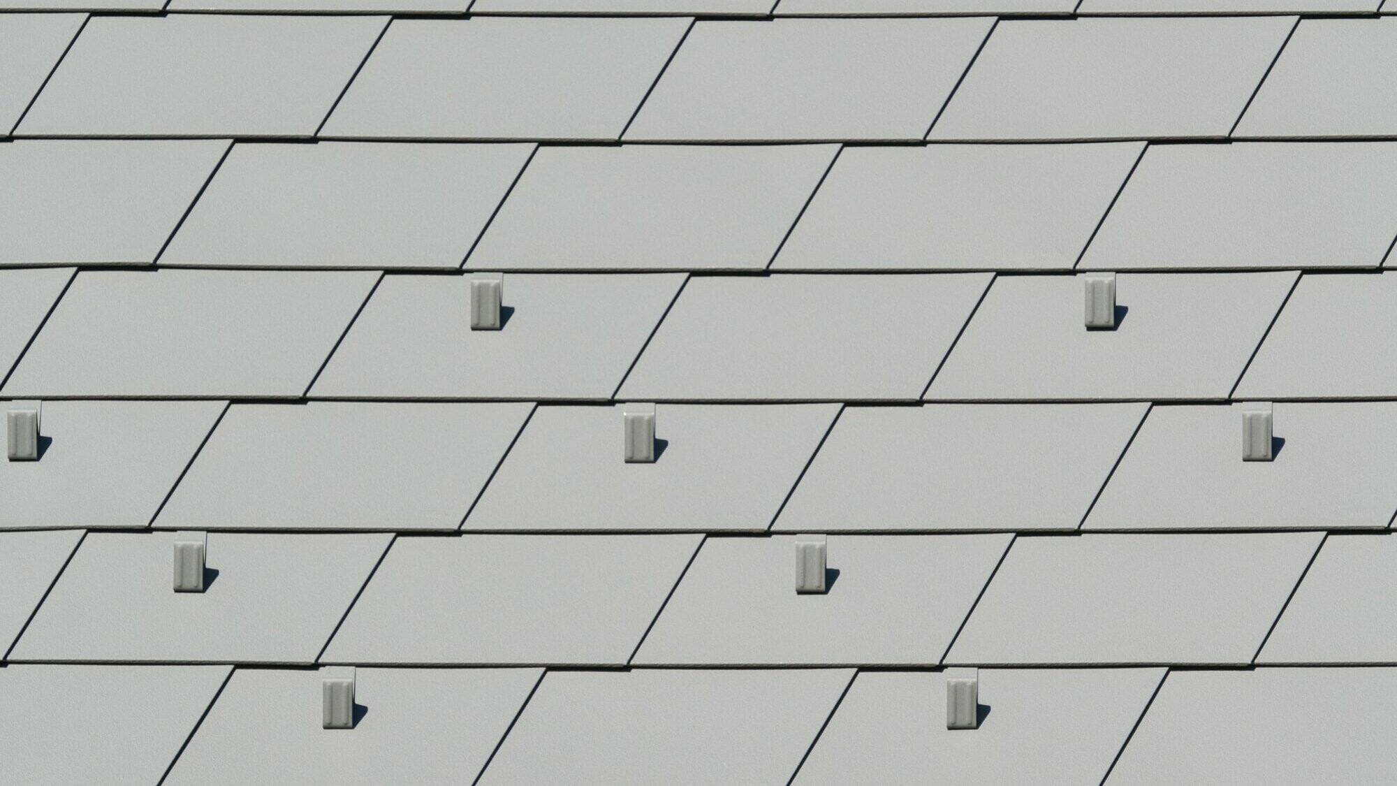 Vue rapprochée de la nouvelle toiture en bardeau PREFA dans la teinte P.10 gris souris stucco