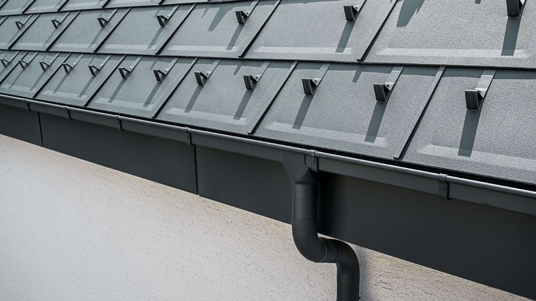 Surface de toit raide recouverte de R.16 avec gouttière carrée, naissance et descente de gouttière PREFA couleur anthracite