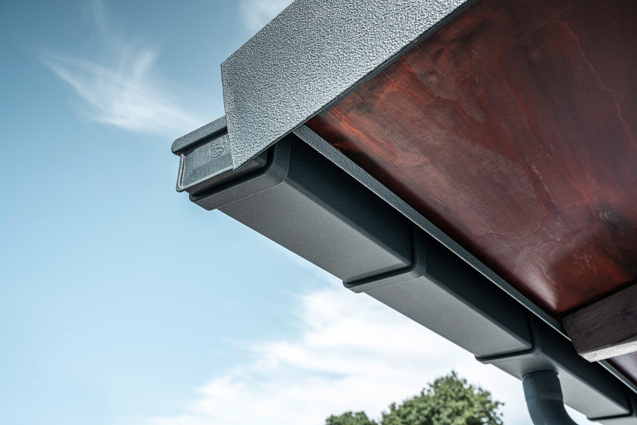 Détail du système d'évacuation des eaux pluviales PREFA en P.10 anthracite sur la toiture d'une maison individuelle à Dortmund.