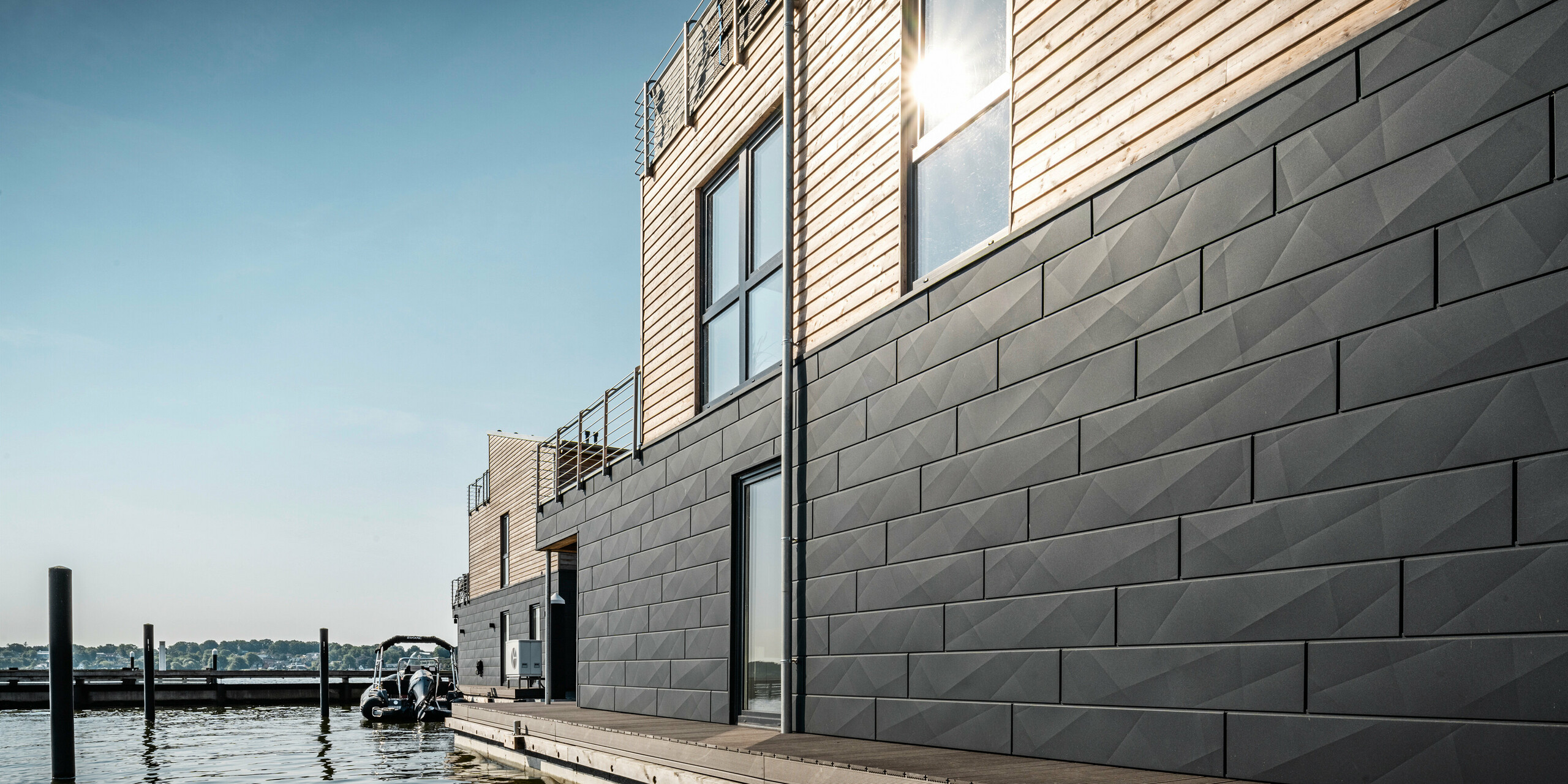 La façade en aluminium Siding.X PREFA entoure onze maisons flottantes dans le port pionnier du Schleswig.