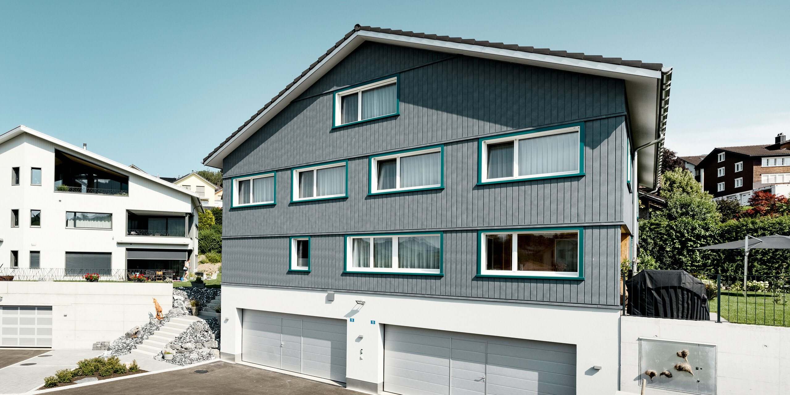 Sidings PREFA en gris pierre P.10 et blanc Prefa P.10 sur les façades de deux immeubles d'habitation voisins à Weissbad, en Suisse.