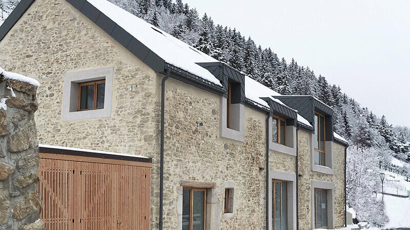 Vue sous la neige de la Grange à Gaby rénovée grâce aux losanges en aluminium PREFA