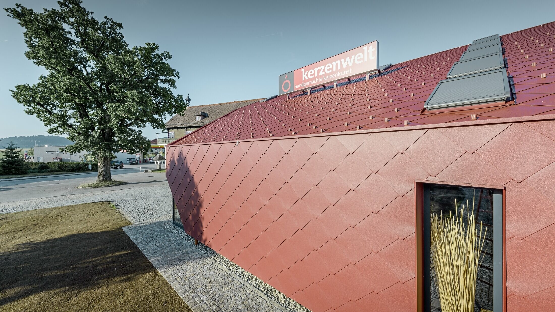 Le Kerzenwelt de Schlägl a été entièrement habillé de losanges PREFA. La couverture de toit et l’habillage de façade ont été réalisés avec le losange 44 × 44 couleur rouge oxyde.