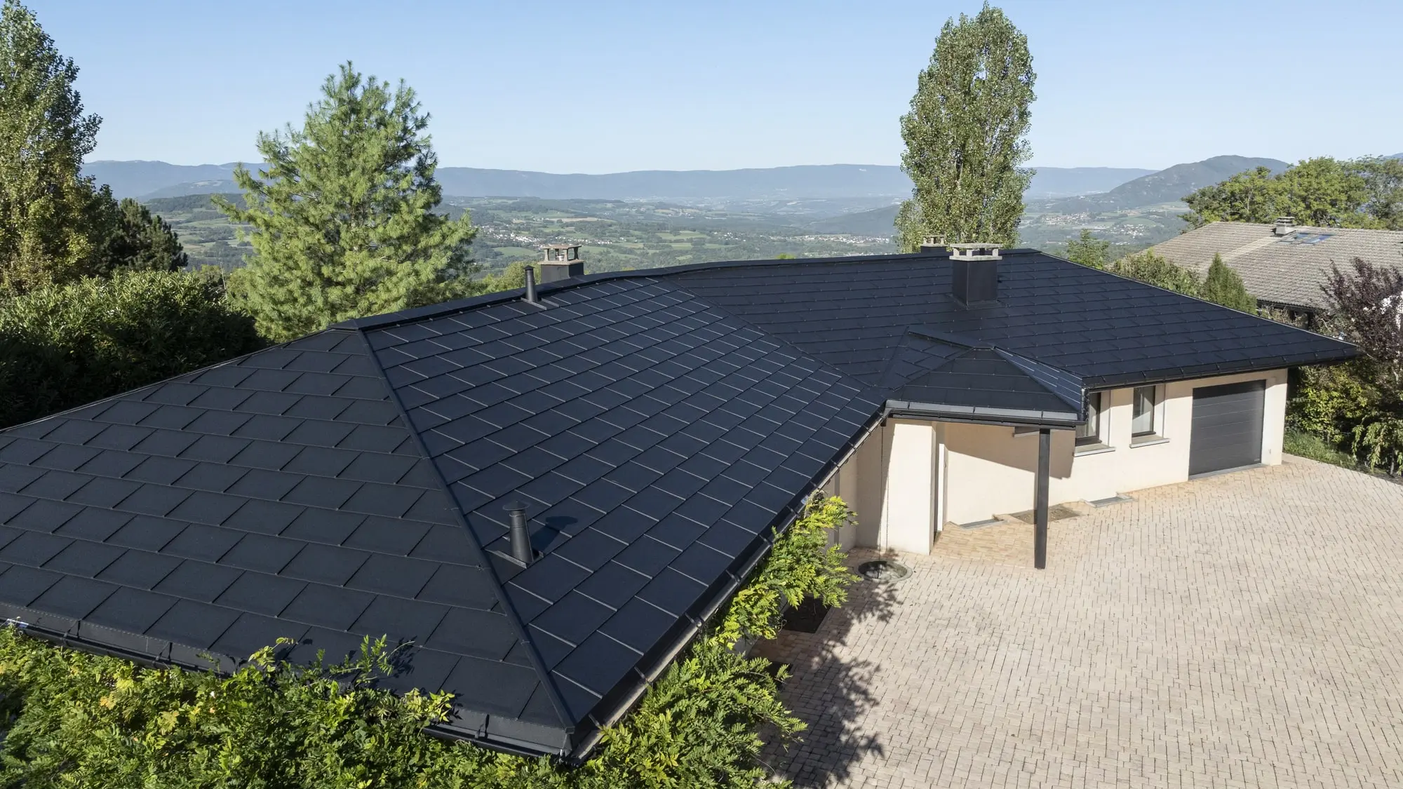 Vue d'ensemble de cette maison individuelle récemment rénovée avec les produits en aluminium PREFA : gouttière demi-ronde, R.16 et joint debout Prefalz en P.10 noir