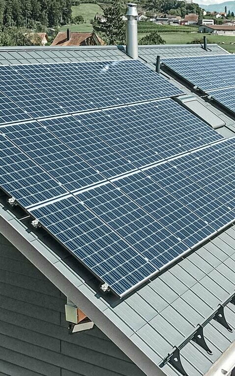PREFA Dachplatte in der Farbe anthrazit mit einer montierten Photovoltaik-Anlage als Aufdach-Lösung.
