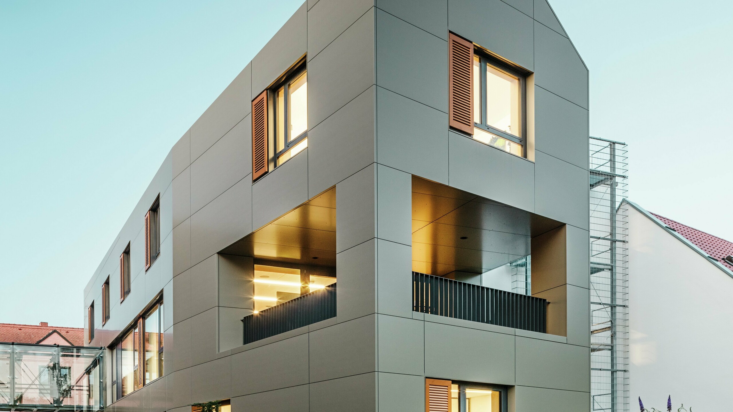 La mairie d'Alzenau, en Allemagne, présente une façade moderne composée de panneaux composites en aluminium PREFA de couleur bronze. Les lignes claires et géométriques des panneaux confèrent au bâtiment un aspect élégant et contemporain. L'extérieur soigné complète l'architecture.