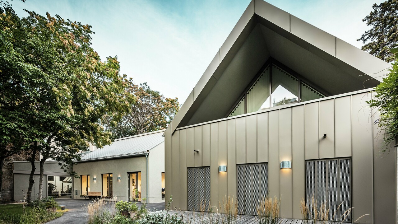 Vue de face du Studio Comploj à Vienne avec une façade en aluminium PREFALZ en P.10 bronze Prefa. L'atelier de soufflage de verre moderne allie artisanat et architecture contemporaine.
