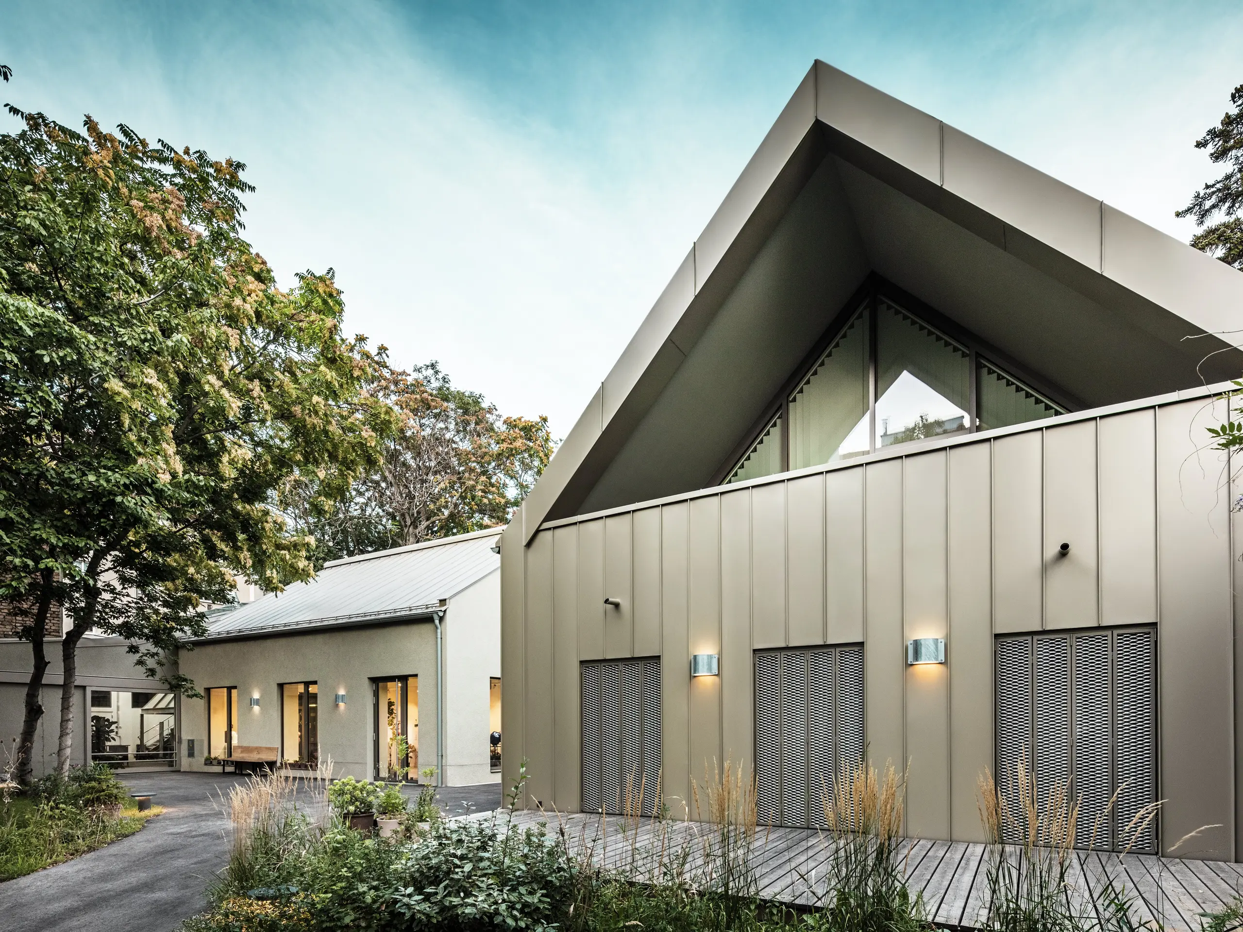 Vue de face du Studio Comploj à Vienne avec une façade en aluminium PREFALZ en P.10 bronze Prefa. L'atelier de soufflage de verre moderne allie artisanat et architecture contemporaine.