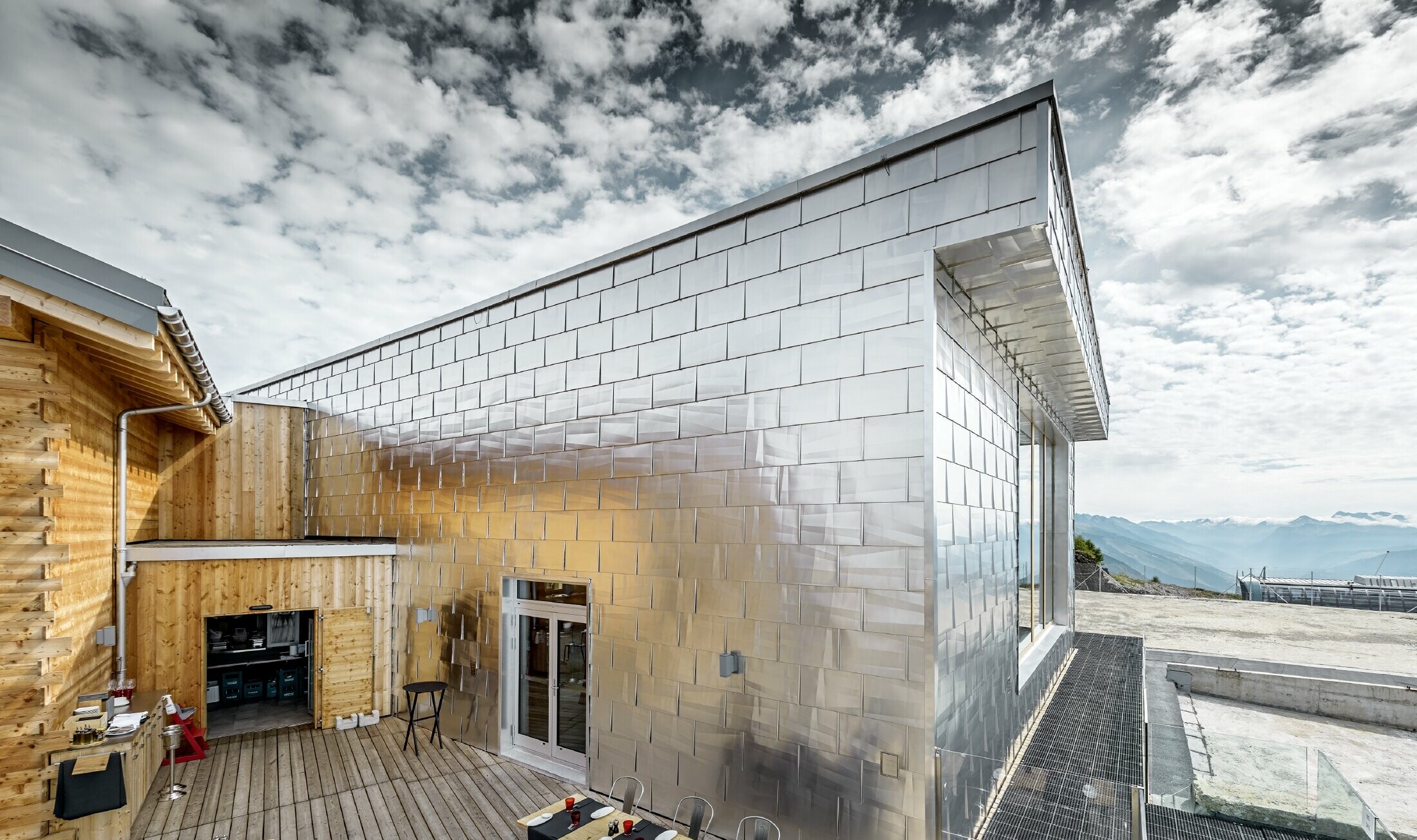 Façade alu chatoyante en alu brillant naturel du Cry D’Er Club d’Altitude en Suisse ; la façade reflète le splendide panorama à 360°.