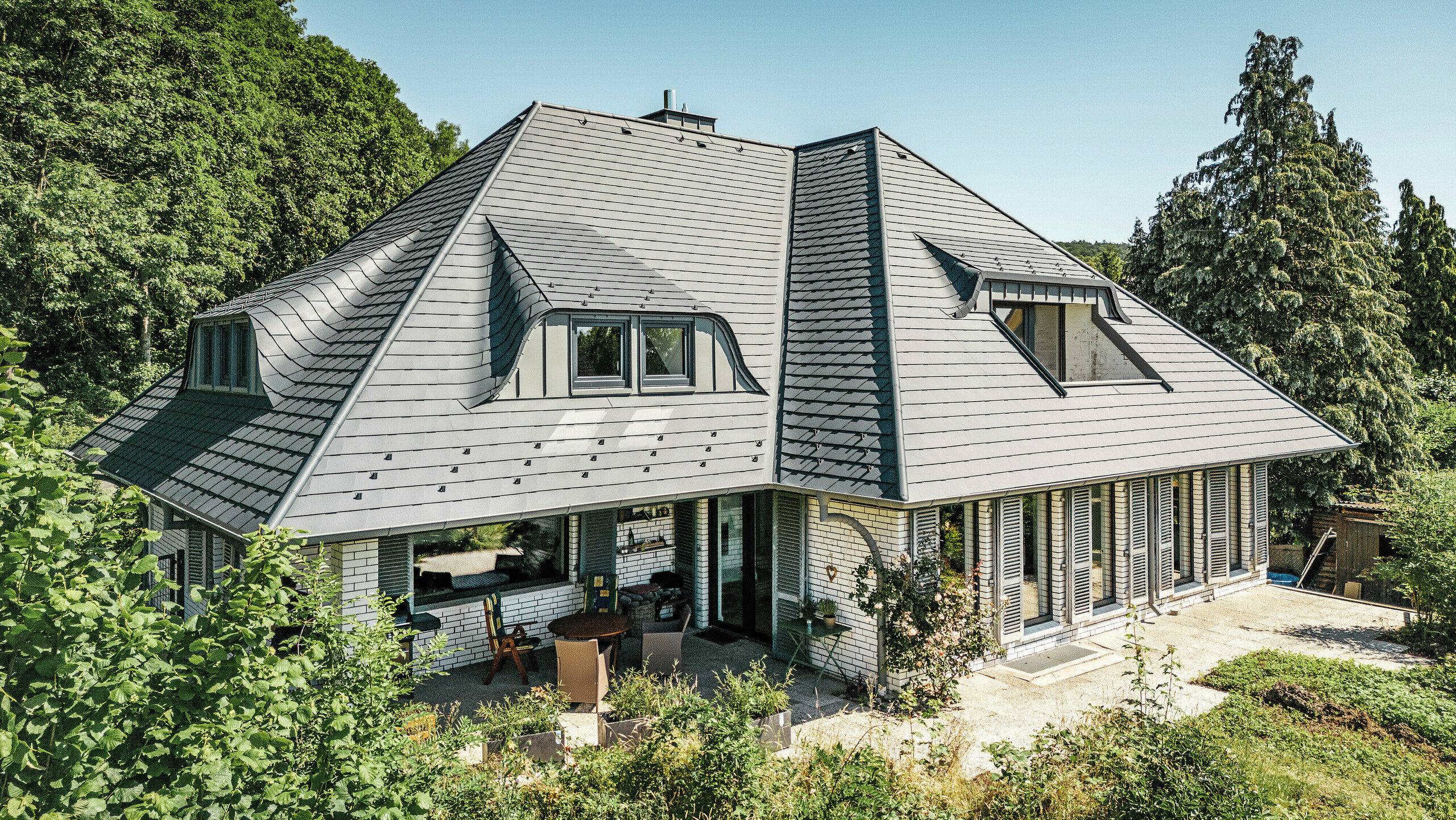 Toiture avec lucarnes cintrées d'une maison individuelle à Einbeck recouverte de bardeaux PREFA en anthracite P.10