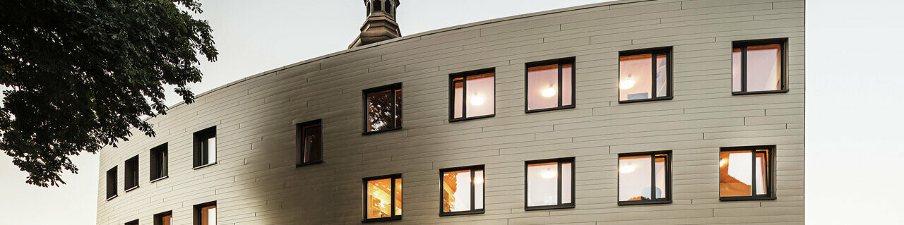 Prise de vue de la résidence universitaire au crépuscule dans un look PREFA avec les Sidings.