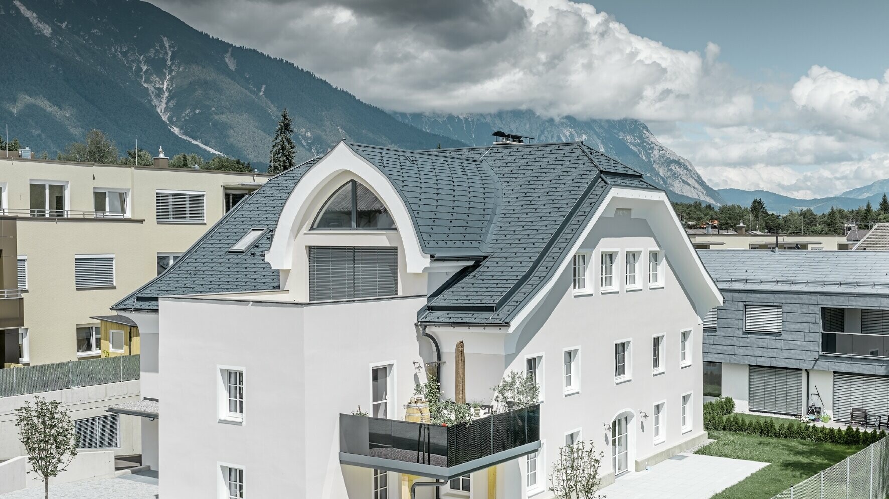 Toit en demi-croupe rénové à l'aide de bardeaux de toiture PREFA en P.10 anthracite, avec lucarne arrondie
