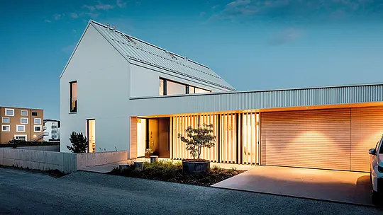 Cette maison individuelle moderne à Freistadt impressionne par son architecture blanche éclatante. La façade en aluminium PREFALZ, aux plis en zigzag, confère au bâtiment une élégance raffinée. Le design minimaliste de la maison est mis en valeur par des éléments en bois chaleureux dans l'entrée et par des sections de façade subtilement éclairées. L'utilisation du matériau PREFALZ, durable et nécessitant peu d'entretien, garantit non seulement une esthétique durable, mais aussi une excellente résistance aux intempéries – un atout majeur pour les projets de construction durables et exigeants.