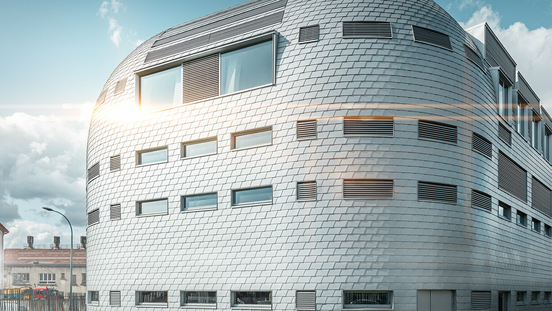 Surface de bâtiment arrondie avec façade PREFA en aluminium de couleur argent métallisé