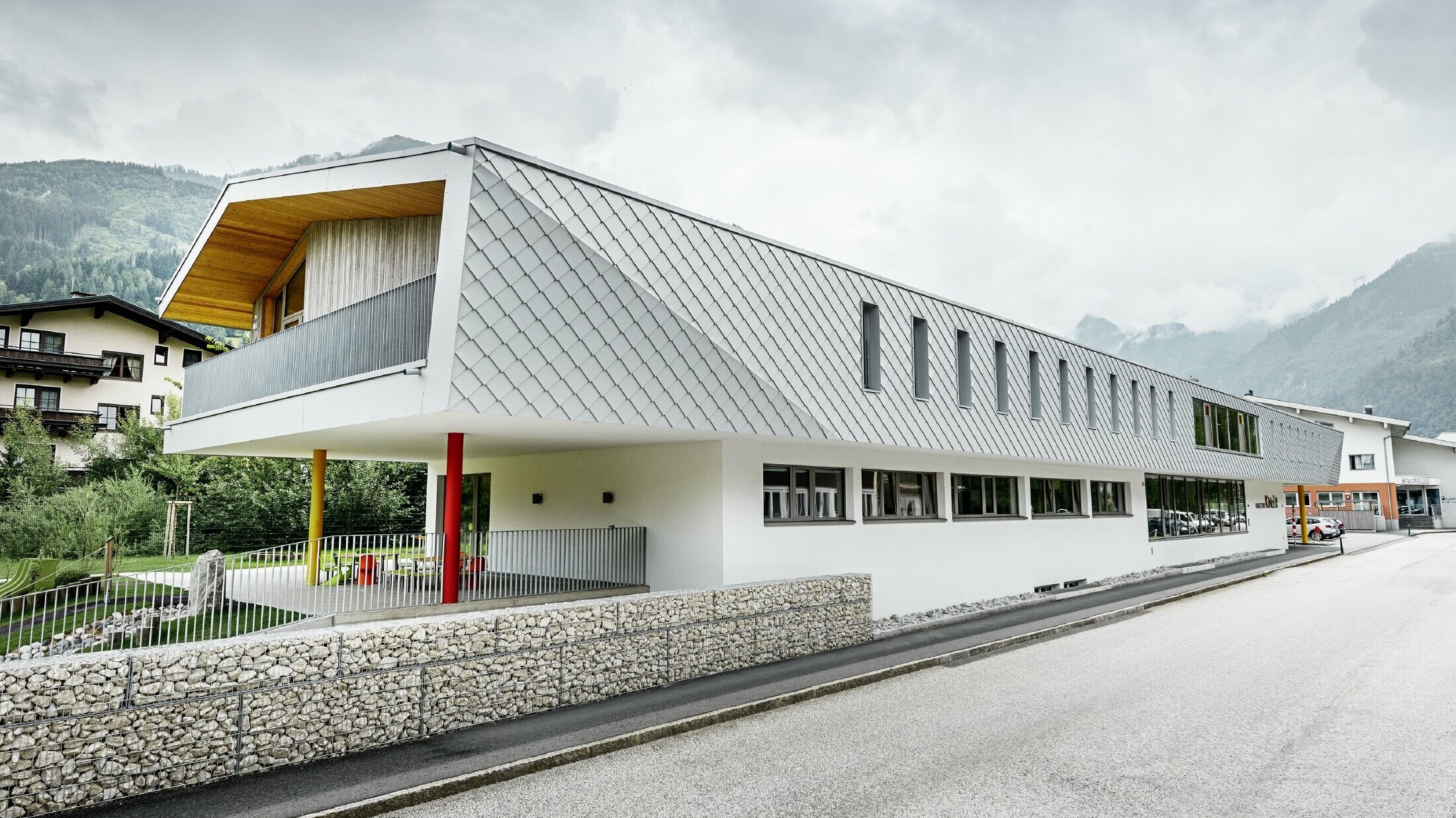 Nouvelle école maternelle de Kaprun — Façade moderne en aluminium réalisée avec des losanges de façade PREFA couleur blanc prefa