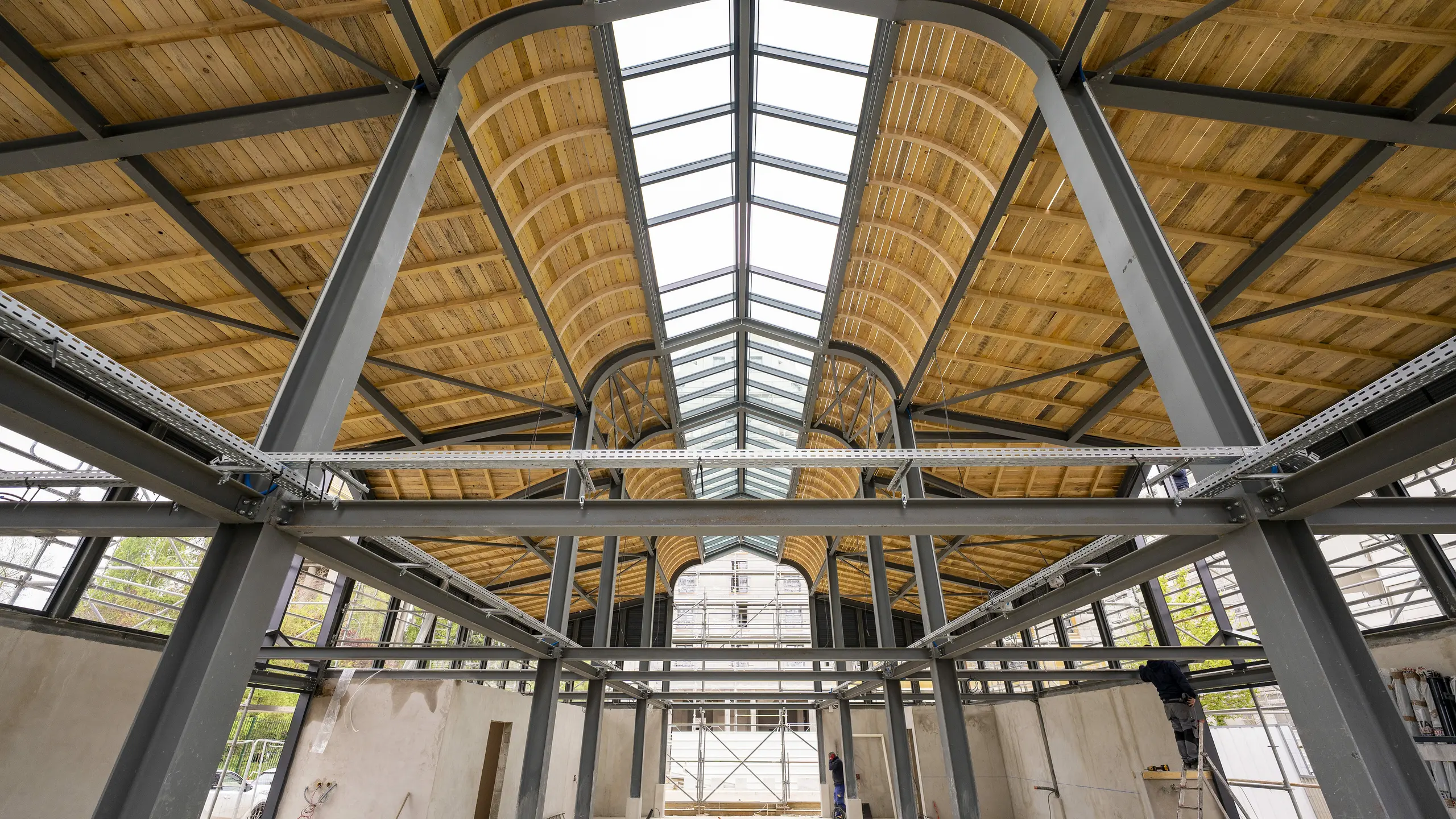 Photo de l'intérieure de la Halle de Clamart encore vide, on aperçoit la charpente métallique et en bois.