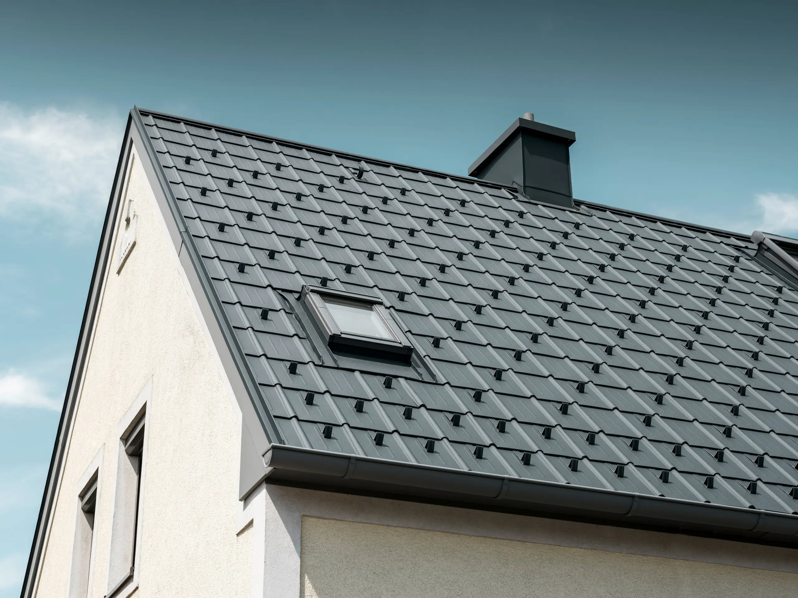 Einfamilienhaus in St. Valentin mit PREFA Dachplatte in anthrazit und einem Dachentwässerungssystem von PREFA in hellgrau