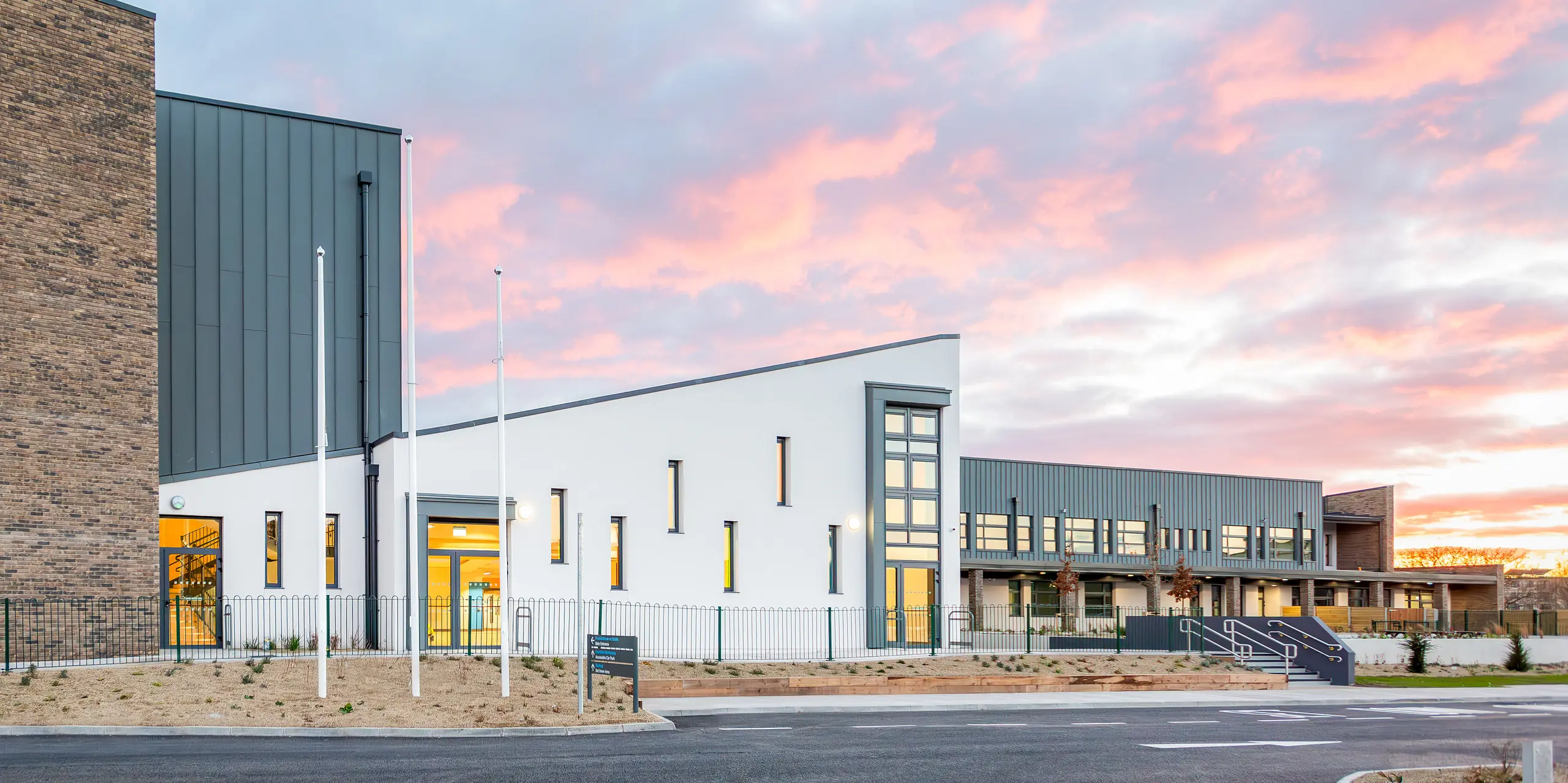 Le bâtiment scolaire moderne de Scoil Mhuire Naofa à Carrigtwohill, en Irlande, présente une façade en aluminium remarquable en PREFALZ en P.10 gris souris. La toiture à joint debout, durable et résistante aux intempéries, couvre environ 800 m² et allie fonctionnalité et esthétique intemporelle. L'architecture de haute qualité prend tout son sens avec en toile de fond un coucher de soleil pittoresque.
