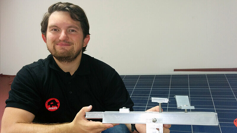 Mitarbeiter Tristan Kirschberger mit dem Solar-Montagesystem von PREFA in der Hand