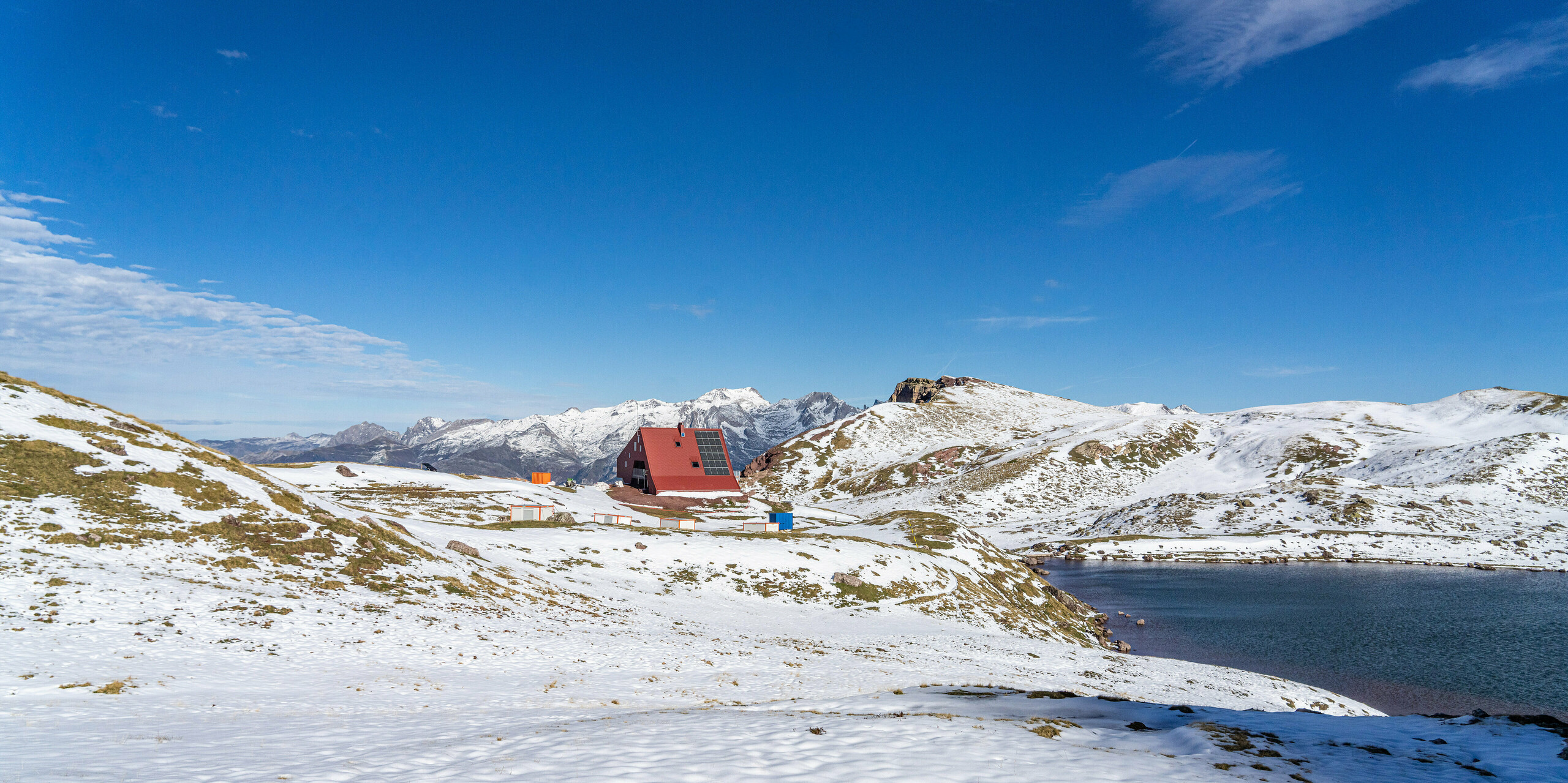 Vue de loin du refuge d'Arlet dans le Parc National des Pyrénées avec neige et montagnes en arrière-plan