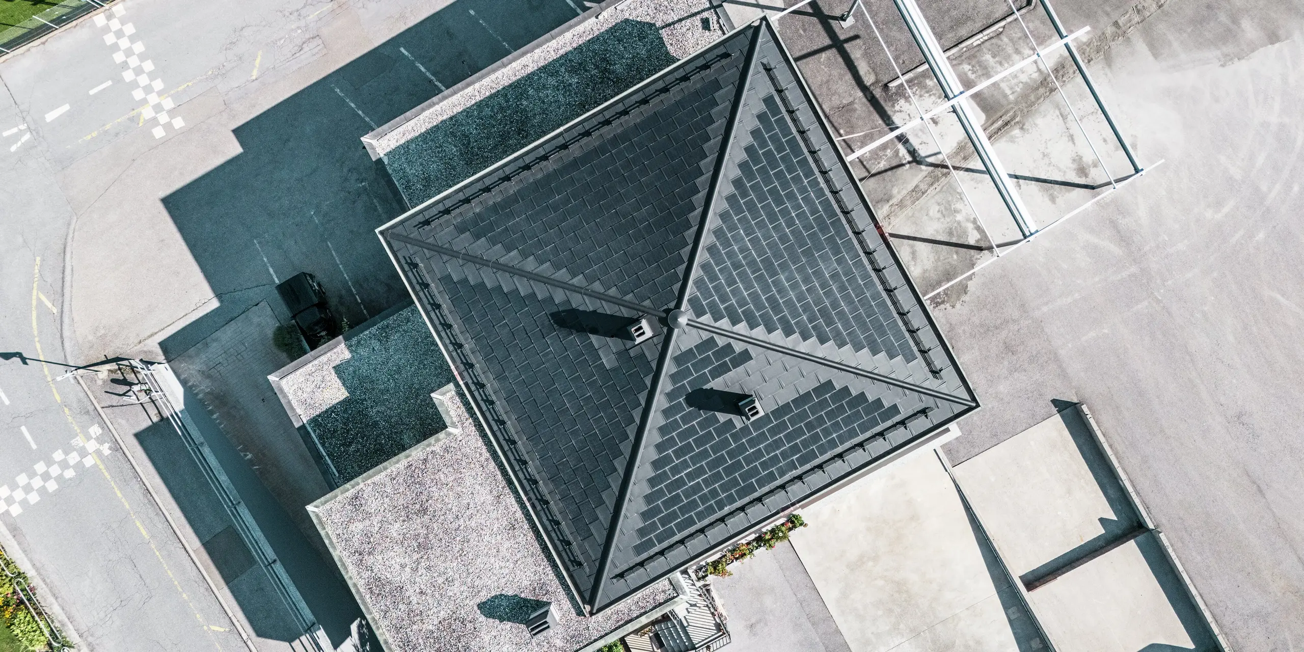Vue de dessus du toit de la cave Leukersonne à Susten. Le toit en aluminium présente une combinaison parfaite d'esthétique et de fonctionnalité. Les tuiles solaires PREFA garantissent une production d'énergie durable avec une durabilité maximale.