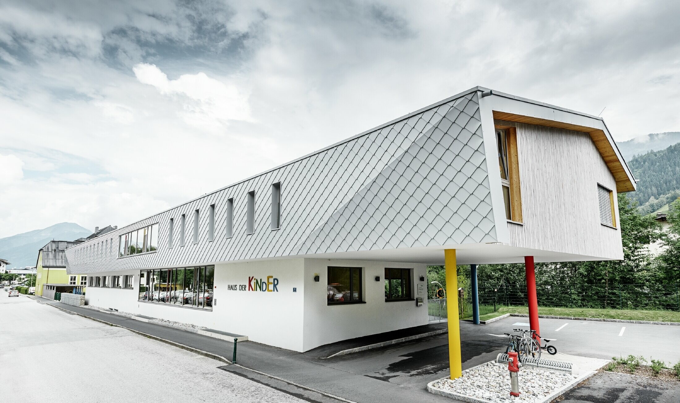 Nouvelle école maternelle de Kaprun — Façade moderne en aluminium réalisée avec des losanges de façade PREFA couleur blanc prefa