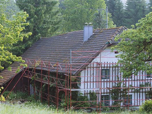 Ancienne toiture de la maison traditionnelle « Wiesenhaus » peu avant sa rénovation avec des bardeaux PREFA (échafaudage en place)